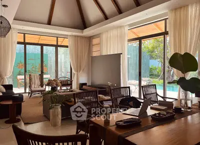 Luxurious open-plan living room with pool view, elegant decor, and abundant natural light.
