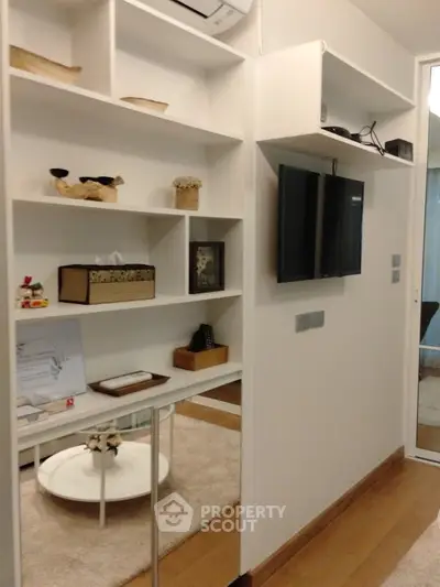 Modern living room with wall-mounted TV and stylish shelving