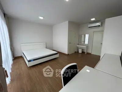 Spacious modern bedroom with minimalist design and wooden flooring