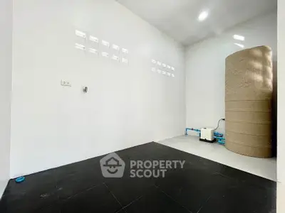 Spacious utility room with water tank and tiled floor in modern home