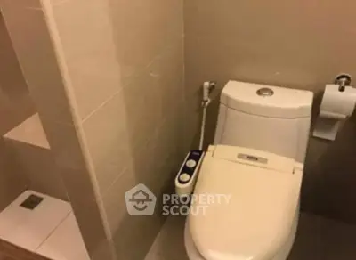 Modern bathroom with sleek toilet and bidet attachment in neutral tones.