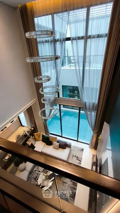 Luxurious modern living room with high ceilings and elegant chandelier