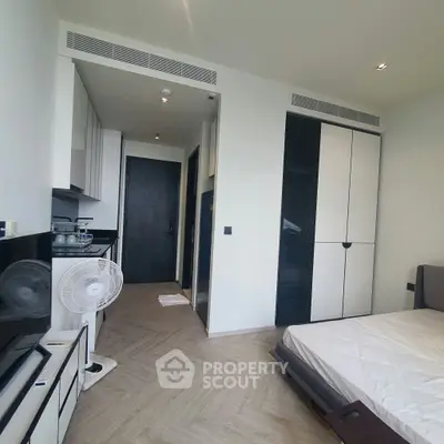 Modern studio apartment with sleek design and compact kitchen area, perfect for urban living.