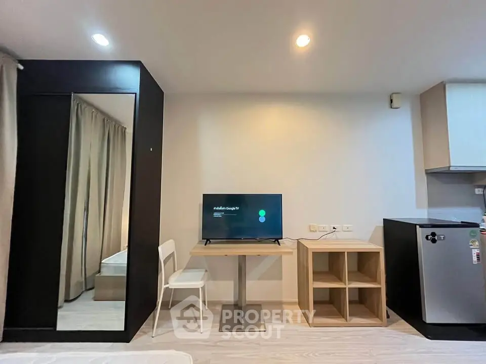 Modern studio apartment with sleek furniture and built-in storage solutions.