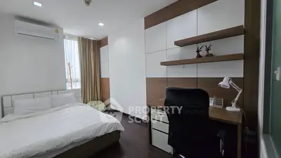 Modern bedroom with study area, featuring sleek furniture and natural light.