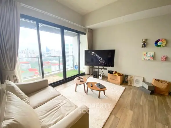 Modern living room with city view, featuring cozy sofa and large TV, perfect for relaxation.