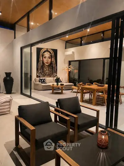 Modern living room with high ceilings, large artwork, and elegant furniture in a stylish open-plan design.