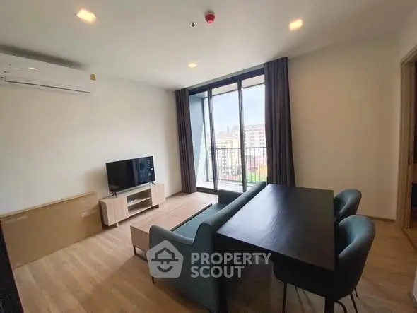 Modern living room with balcony view, sleek furniture, and natural light.