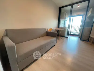 Modern living room with gray sofa and balcony view