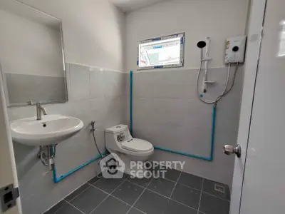 Modern bathroom with sleek fixtures and tiled walls, featuring a shower and toilet.
