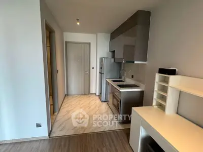 Modern compact kitchen with sleek cabinetry and integrated appliances in a stylish apartment.