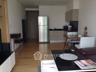 Modern open-layout kitchen with sleek appliances and cozy dining area in stylish apartment.