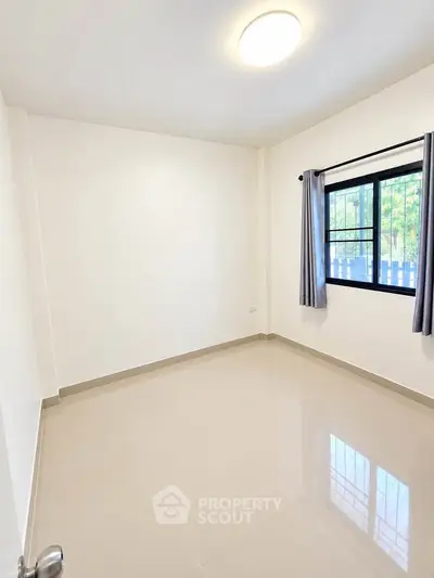 Bright and spacious empty room with large window and tiled floor, perfect for customization.