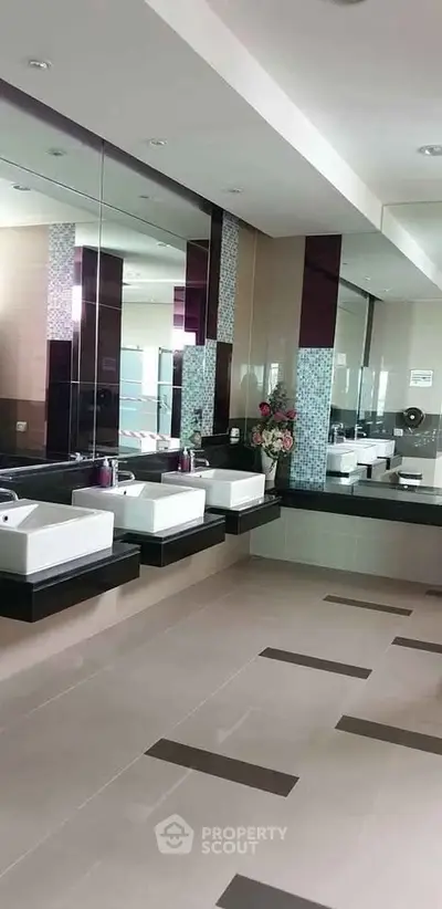 Spacious modern bathroom with sleek sinks and large mirrors, perfect for luxury living.