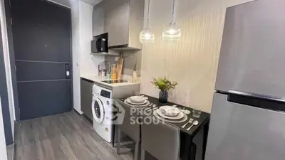 Modern compact kitchen with washing machine and dining area in stylish apartment