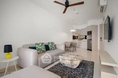 Modern living room with open kitchen, stylish decor, and ceiling fan in a contemporary apartment.