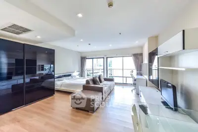 Spacious modern studio apartment with large windows and sleek furnishings