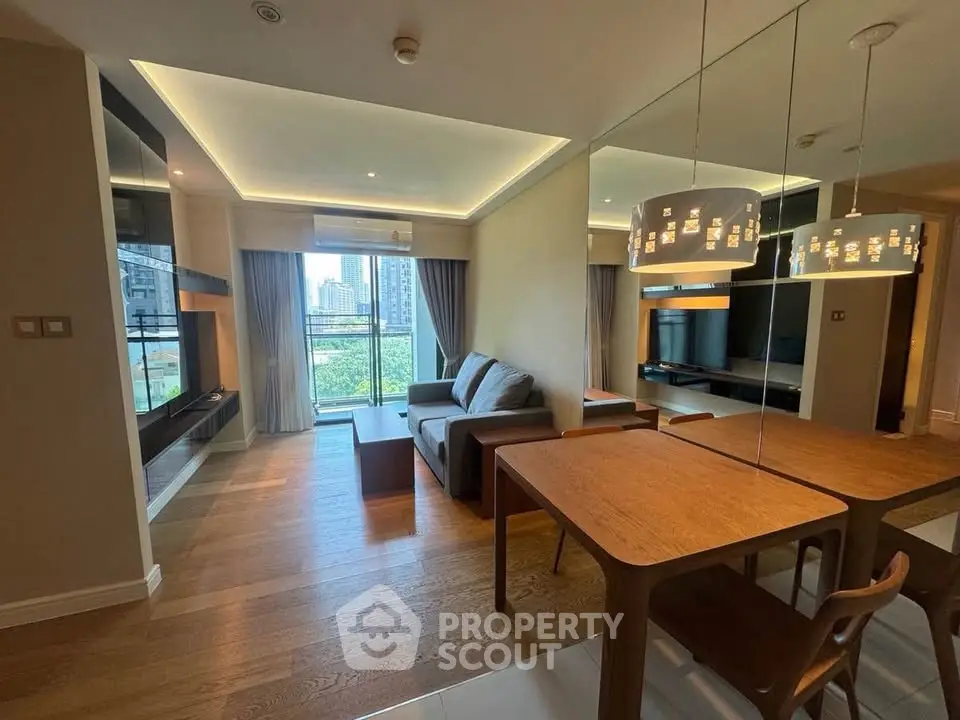 Modern living room with stylish furniture and large windows offering city views.