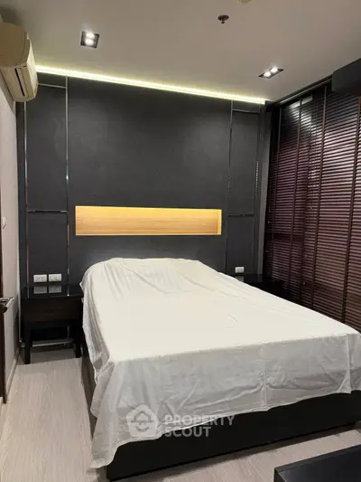 Modern bedroom with sleek design and ambient lighting, featuring a comfortable bed and stylish decor.