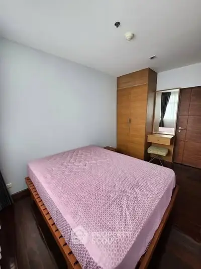 Spacious bedroom with wooden furniture and ample natural light