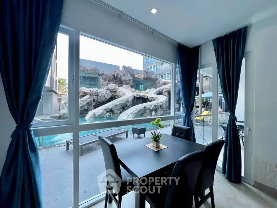 Luxurious dining area with stunning pool view and water slides, perfect for entertaining.