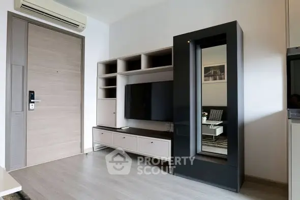 Modern living room with sleek furniture and wall-mounted TV in a stylish apartment.