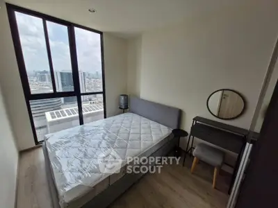 Modern bedroom with city view, featuring a cozy bed and stylish furniture, perfect for urban living.