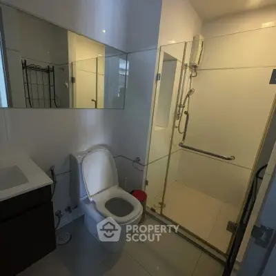Modern bathroom with glass shower and sleek fixtures in a contemporary home.