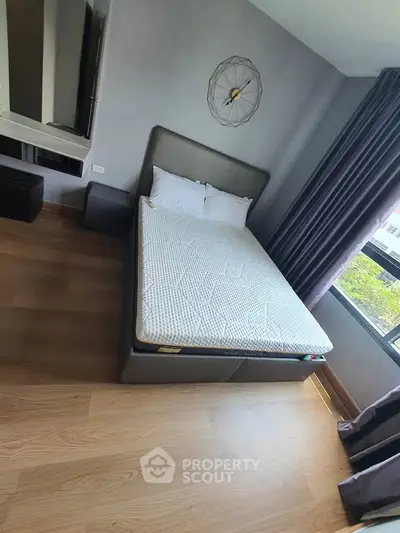 Modern bedroom with stylish decor and large window offering natural light