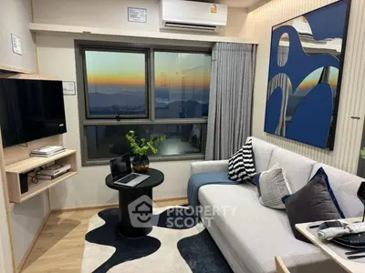 Modern living room with stylish decor and stunning sunset view through large window.