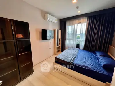 Modern bedroom with sleek furniture and large window offering natural light.