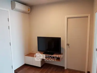 Modern living room with wall-mounted TV and air conditioning unit.