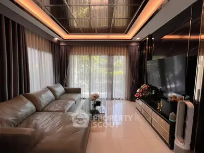 Luxurious living room with modern decor, large sofa, and floor-to-ceiling windows offering garden views.