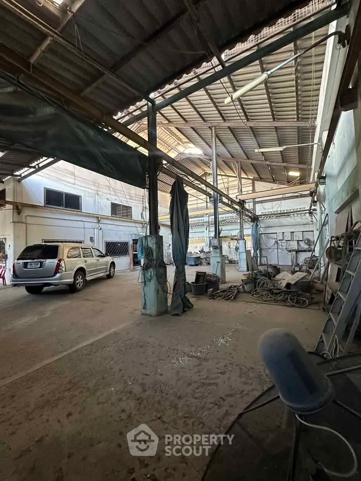 Spacious industrial warehouse with high ceilings and ample parking space.