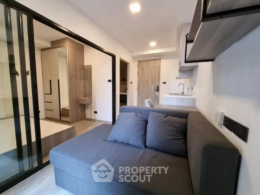 Modern living room with sleek design and cozy sofa in a compact apartment.