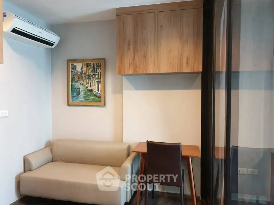 Cozy living room with modern sofa, wall art, and wooden desk in a stylish apartment.