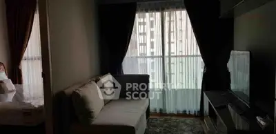 Cozy living room with modern sofa and large window offering natural light in urban apartment.
