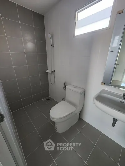 Modern bathroom with sleek tiles and compact fixtures