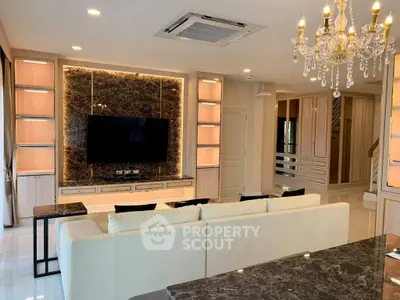 Luxurious living room with elegant chandelier and modern entertainment center