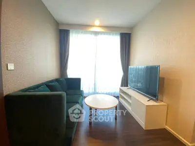 Cozy living room with modern sofa and flat-screen TV, perfect for relaxation.
