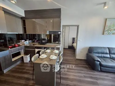 Modern open-layout kitchen and living room with sleek design and cozy ambiance.