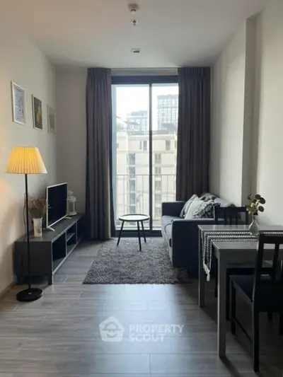 Modern living room with balcony view, stylish decor, and cozy seating area in urban apartment.