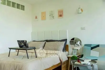 Cozy bedroom with modern decor and laptop on bed, perfect for relaxation and work-from-home setup.