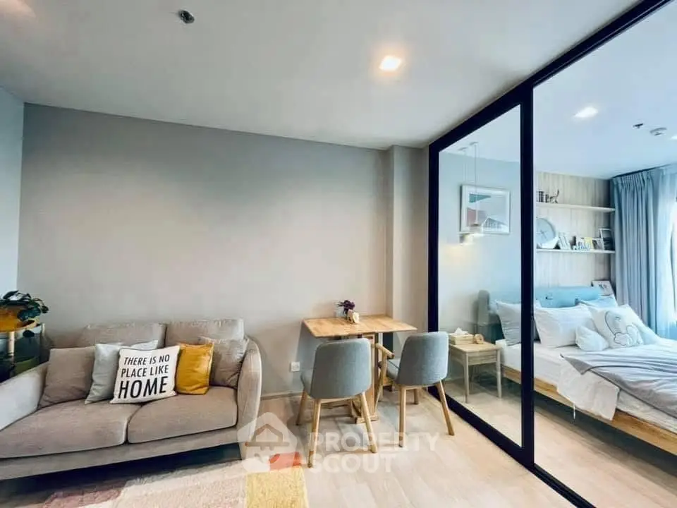 Modern open-plan living room with cozy seating and stylish dining area adjacent to a bright bedroom.