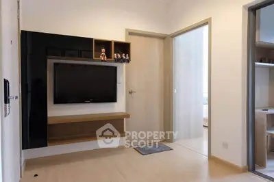 Modern living room with sleek TV unit and wooden flooring in a stylish apartment.