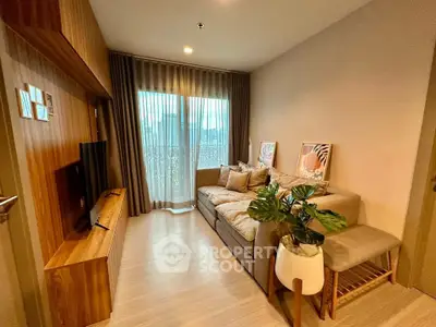 Cozy living room with modern decor and large window for natural light.