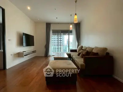 Spacious living room with modern decor and city view balcony, perfect for urban living.