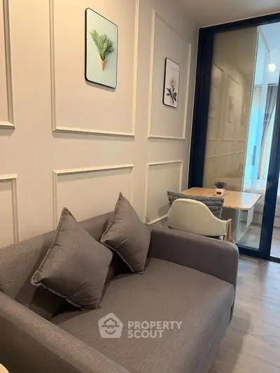 Stylish modern living room with cozy gray sofa and elegant wall decor, perfect for urban living.