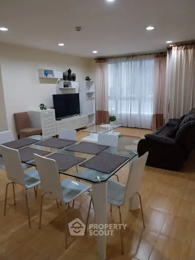 Spacious living room with modern furniture and dining area, featuring large windows and elegant decor.