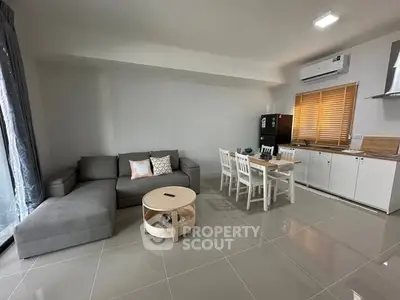 Modern living room with sleek furniture and open kitchen layout, perfect for contemporary living.